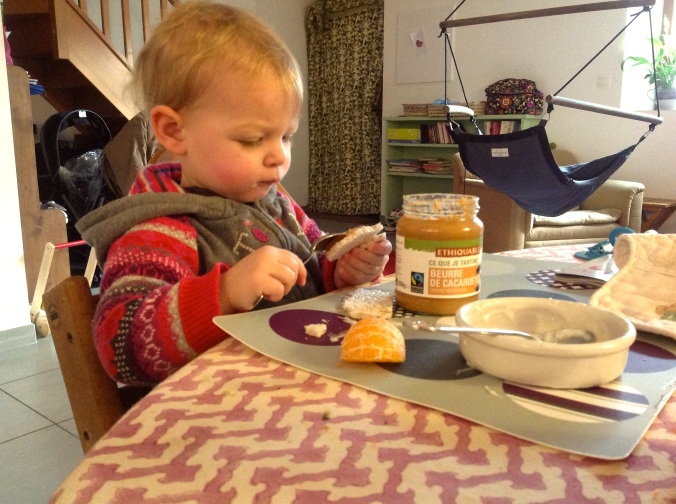 This little girl likes eating  peanut butter off rice crackers for breakfast. 